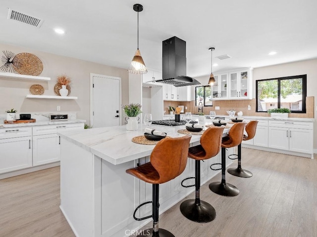 971 N Clifford Ave, Rialto, CA 92376 - kitchen featuring island exhaust hood, open shelves, a center island, light wood finished floors, and backsplash