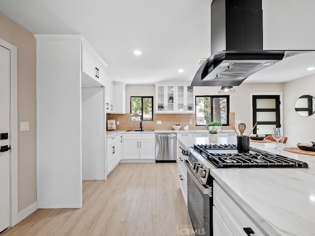 971 N Clifford Ave, Rialto, CA 92376 - kitchen with stainless steel appliances, ventilation hood, light wood-style floors, glass insert cabinets, and tasteful backsplash