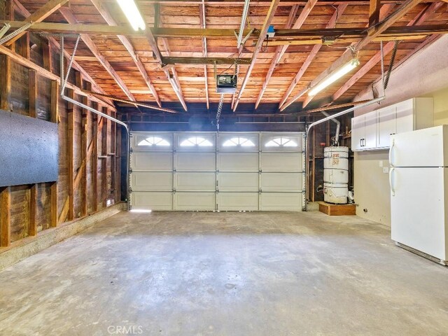 971 N Clifford Ave, Rialto, CA 92376 - garage featuring freestanding refrigerator, a garage door opener, and strapped water heater