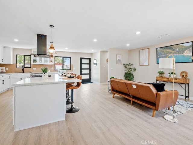 971 N Clifford Ave, Rialto, CA 92376 - kitchen with island range hood, light wood-style flooring, white cabinets, light countertops, and recessed lighting