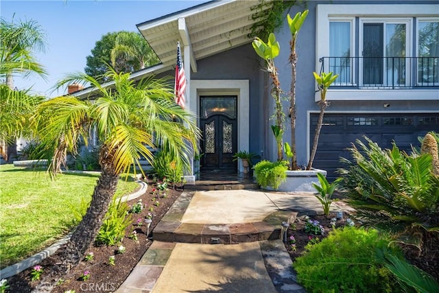 26301 Montarez Cir, Mission Viejo, CA 92691 - view of exterior entry with french doors, stucco siding, a yard, a garage, and a balcony