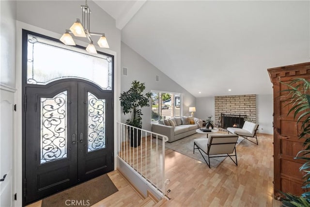 26301 Montarez Cir, Mission Viejo, CA 92691 - foyer with french doors, high vaulted ceiling, light wood finished floors, and a fireplace