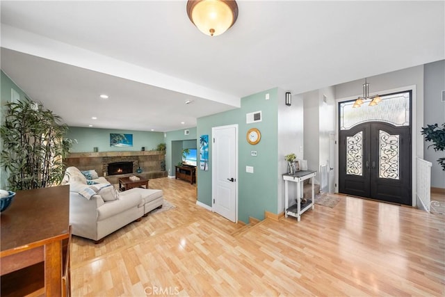 26301 Montarez Cir, Mission Viejo, CA 92691 - living room with light wood-style floors, a stone fireplace, french doors, and recessed lighting