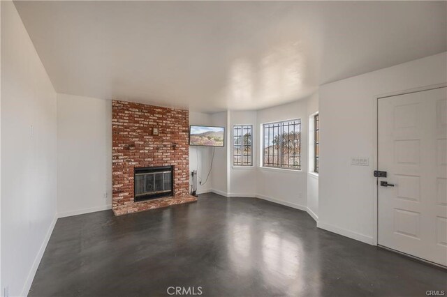 72011 Two Mile Rd Unit 29, Palms, CA 92277 - unfurnished living room featuring a fireplace and finished concrete floors
