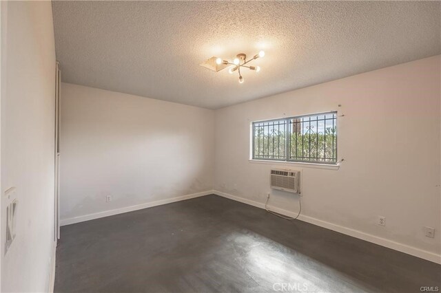 72011 Two Mile Rd Unit 29, Palms, CA 92277 - empty room with a wall mounted AC, a textured ceiling, and a chandelier
