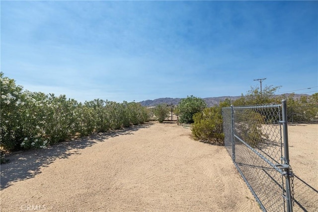72011 Two Mile Rd Unit 29, Palms, CA 92277 - view of dirt / gravel driveway with a gated entry, a gate, a view of countryside, and a mountain view