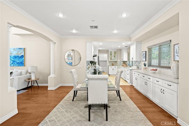 826 Country Oaks Ln, Arcadia, CA 91006 - dining space featuring arched walkways, crown molding, wood finished floors, decorative columns, and recessed lighting
