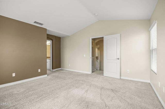 724 Parrish St, Ventura, CA 93003 - unfurnished bedroom with light colored carpet, vaulted ceiling, arched walkways, and ensuite bathroom
