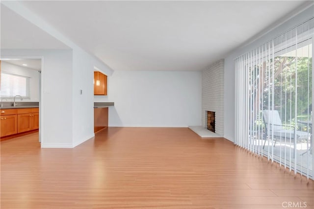 22913 Nadine Cir Unit A, Torrance, CA 90505 - unfurnished living room featuring light wood finished floors, plenty of natural light, and a fireplace