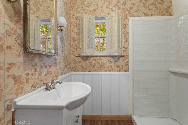 733 W 24th St, San Bernardino, CA 92405 - full bath featuring wallpapered walls, vanity, a shower, a wainscoted wall, and wood finished floors
