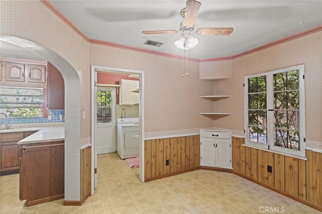 733 W 24th St, San Bernardino, CA 92405 - kitchen with washer / clothes dryer, arched walkways, ornamental molding, light countertops, and light flooring