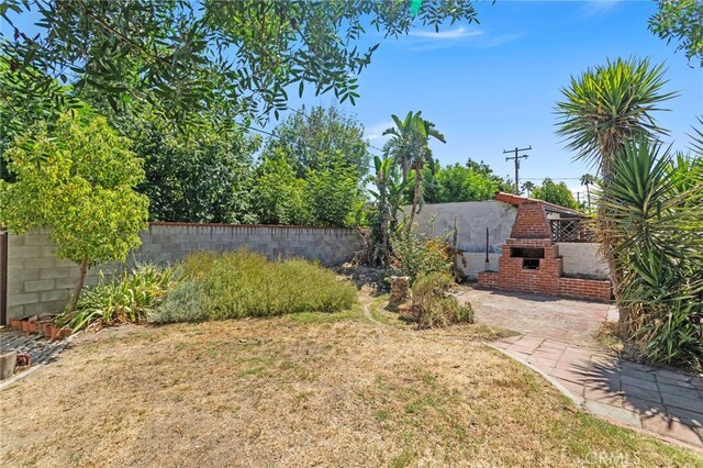 733 W 24th St, San Bernardino, CA 92405 - view of yard with an outdoor brick fireplace