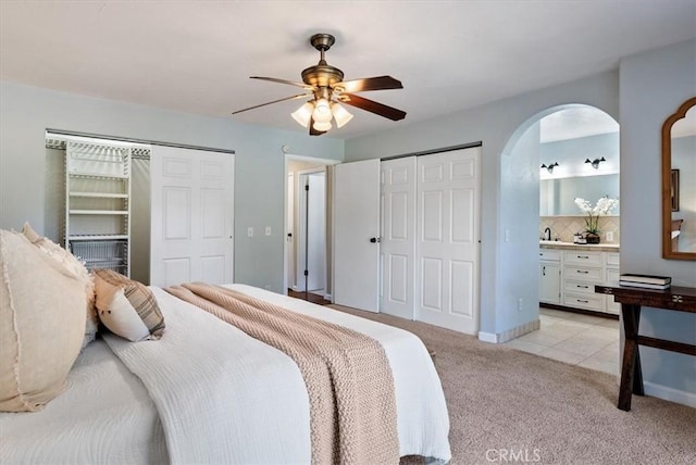 553 Well Rd, Templeton, CA 93465 - bedroom with two closets, light carpet, arched walkways, ceiling fan, and ensuite bath