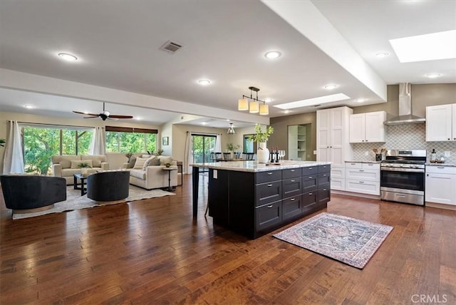 553 Well Rd, Templeton, CA 93465 - kitchen featuring gas range, wall chimney range hood, white cabinets, open floor plan, and healthy amount of natural light