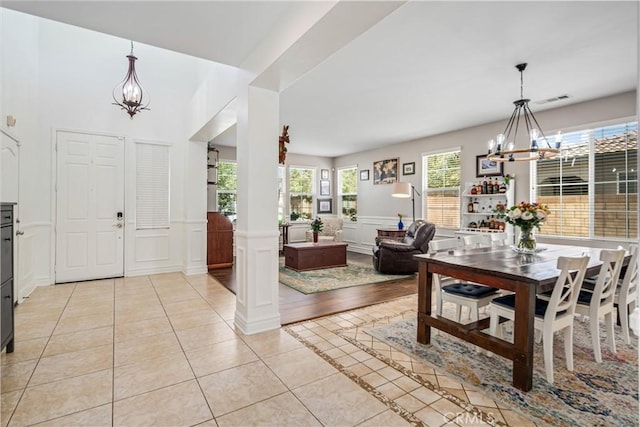 43145 62nd St W, Lancaster, CA 93536 - dining area with a chandelier, a decorative wall, light tile patterned flooring, wainscoting, and decorative columns