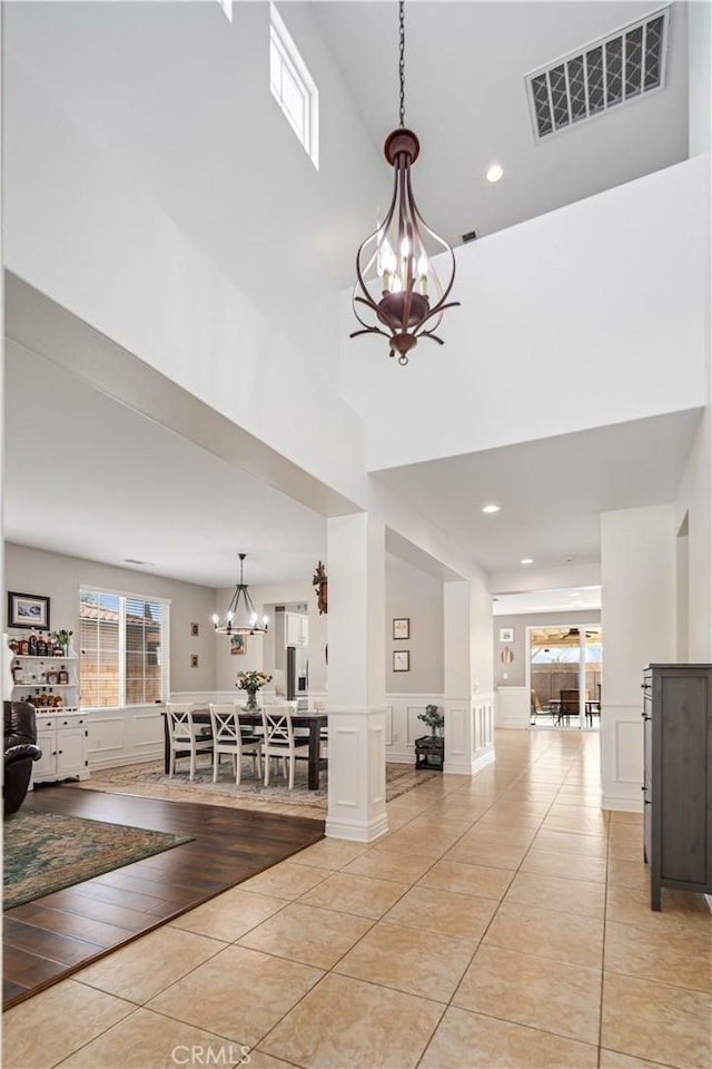 43145 62nd St W, Lancaster, CA 93536 - hallway with a chandelier, a decorative wall, a high ceiling, light tile patterned flooring, and recessed lighting