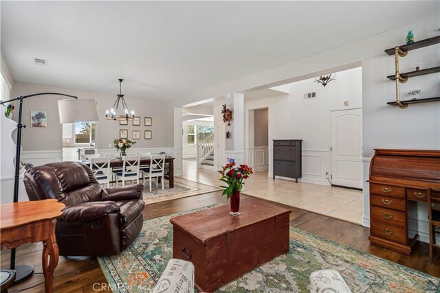 43145 62nd St W, Lancaster, CA 93536 - living area with a chandelier, a decorative wall, wood finished floors, and wainscoting