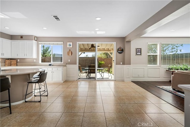 43145 62nd St W, Lancaster, CA 93536 - kitchen with light countertops, healthy amount of natural light, white cabinetry, a wainscoted wall, and a decorative wall