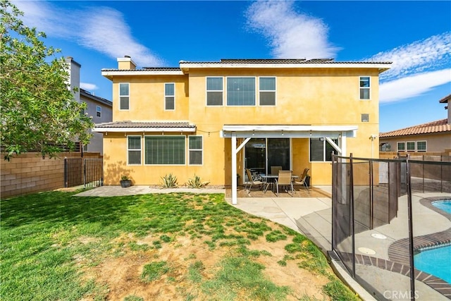 43145 62nd St W, Lancaster, CA 93536 - rear view of house featuring a fenced backyard, stucco siding, a chimney, a patio area, and a tiled roof