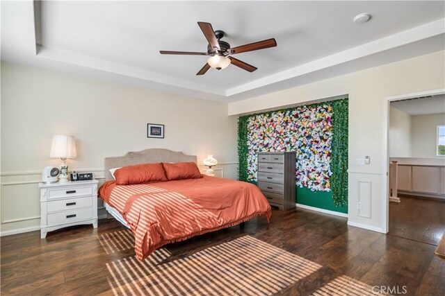 43145 62nd St W, Lancaster, CA 93536 - bedroom featuring wood finished floors, a tray ceiling, a decorative wall, a wainscoted wall, and ceiling fan