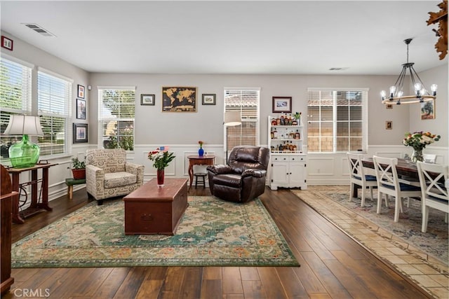 43145 62nd St W, Lancaster, CA 93536 - living room with a chandelier, wainscoting, dark wood finished floors, and a decorative wall