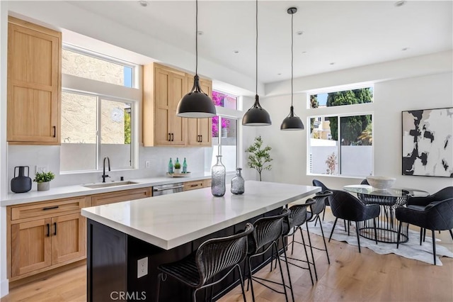 2102 Marshallfield Ln Unit B, Redondo Beach, CA 90278 - kitchen featuring light wood finished floors, light countertops, a breakfast bar area, hanging light fixtures, and light brown cabinetry