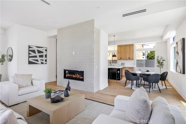 2102 Marshallfield Ln Unit B, Redondo Beach, CA 90278 - living room featuring light wood-type flooring and a brick fireplace