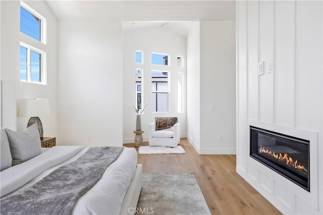 2102 Marshallfield Ln Unit B, Redondo Beach, CA 90278 - bedroom with light wood-style flooring, a glass covered fireplace, and vaulted ceiling