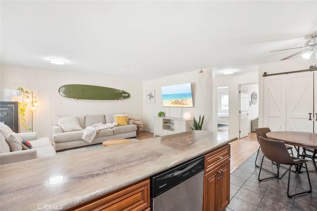 631 7th St Unit 11, Imperial Beach, CA 91932 - kitchen with stainless steel dishwasher, a barn door, brown cabinetry, open floor plan, and a ceiling fan