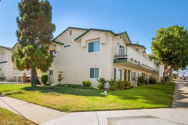 631 7th St Unit 11, Imperial Beach, CA 91932 - view of property exterior featuring stucco siding, a lawn, and a balcony