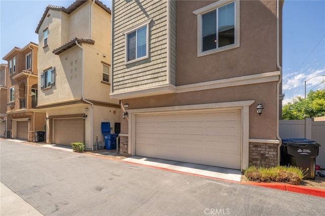 797 Plum Ln, Pomona, CA 91767 - townhome / multi-family property featuring a garage, stone siding, and stucco siding