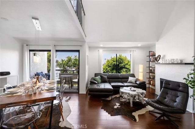 1237 E 6th St Unit 306, Long Beach, CA 90802 - living room with wood-type flooring, a brick fireplace, and a towering ceiling