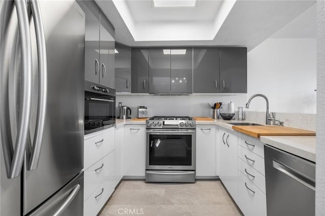 1237 E 6th St Unit 306, Long Beach, CA 90802 - kitchen featuring stainless steel appliances, a tray ceiling, modern cabinets, and white cabinets