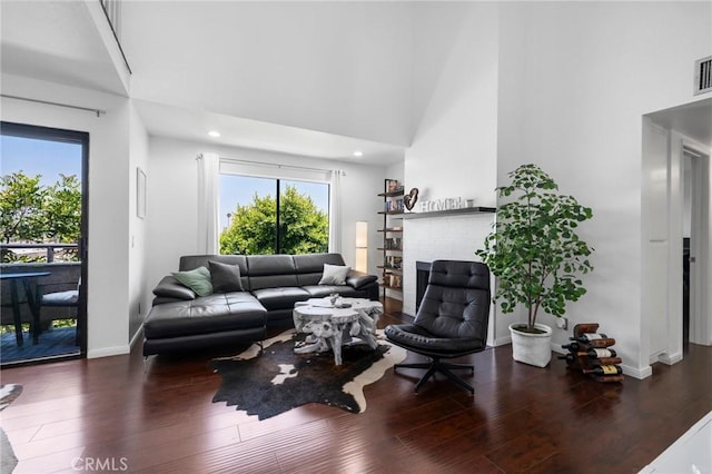 1237 E 6th St Unit 306, Long Beach, CA 90802 - living area featuring a fireplace, wood finished floors, and a high ceiling