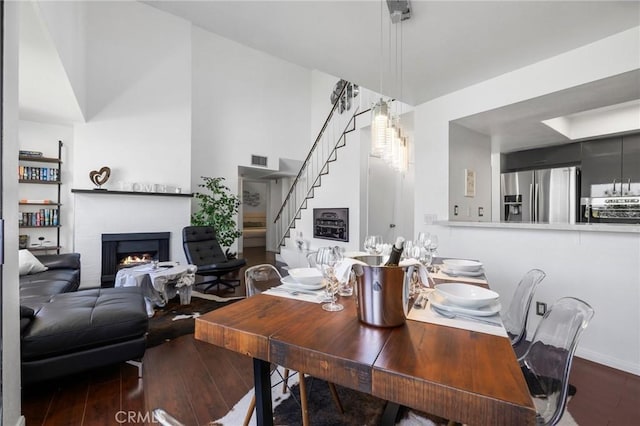 1237 E 6th St Unit 306, Long Beach, CA 90802 - dining area with wood-type flooring, a lit fireplace, and stairway