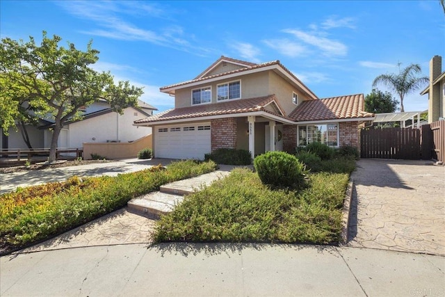 9858 Via Caceres, San Diego, CA 92129 - view of front of home featuring a tile roof, concrete driveway, brick siding, stucco siding, and an attached garage