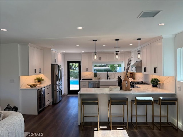 17532 Hamlin St, Lake Balboa, CA 91406 - kitchen with wine cooler, stainless steel appliances, a peninsula, dark wood-type flooring, and white cabinetry