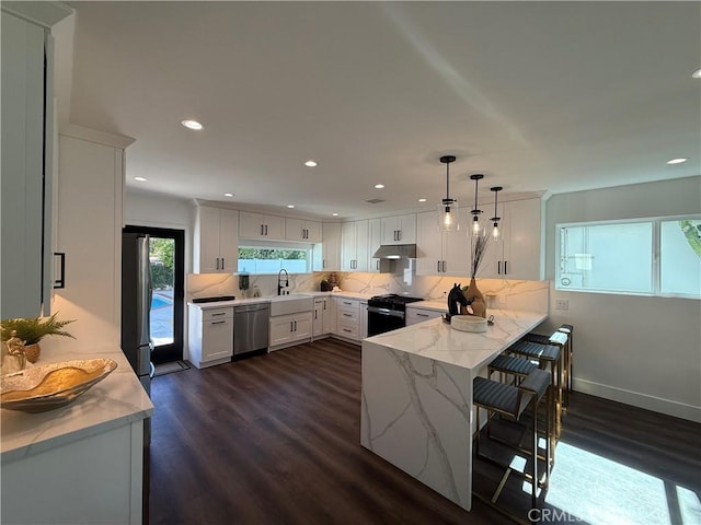 17532 Hamlin St, Lake Balboa, CA 91406 - kitchen featuring dishwasher, black range with gas cooktop, a peninsula, dark wood-style flooring, and under cabinet range hood