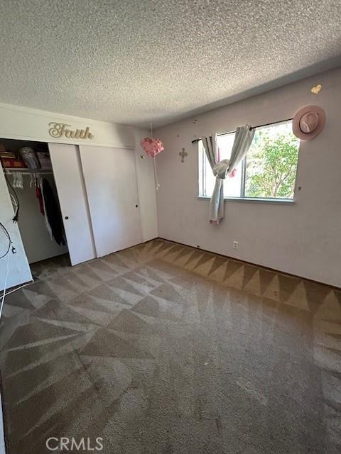 18145 10th St, Bloomington, CA 92316 - unfurnished bedroom with a textured ceiling, carpet, and a closet