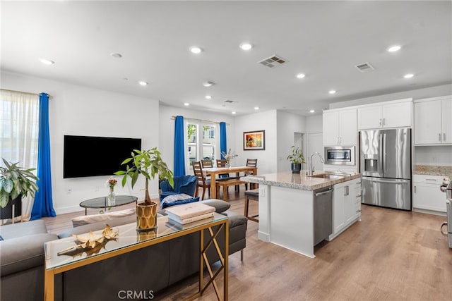 12062 Turnleaf Ave, Whittier, CA 90602 - kitchen featuring stainless steel appliances, light wood finished floors, light stone counters, white cabinets, and recessed lighting