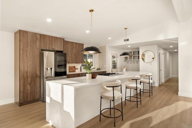835 Cathy Ln, Cardiff By The Sea, CA 92007 - kitchen with stainless steel appliances, brown cabinets, a large island, light wood-type flooring, and light countertops