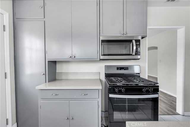 6017 Brockton Ave, Riverside, CA 92506 - kitchen with stainless steel appliances, gray cabinetry, light countertops, and wood finished floors