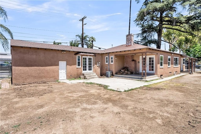 6017 Brockton Ave, Riverside, CA 92506 - rear view of house featuring stucco siding, a chimney, and french doors
