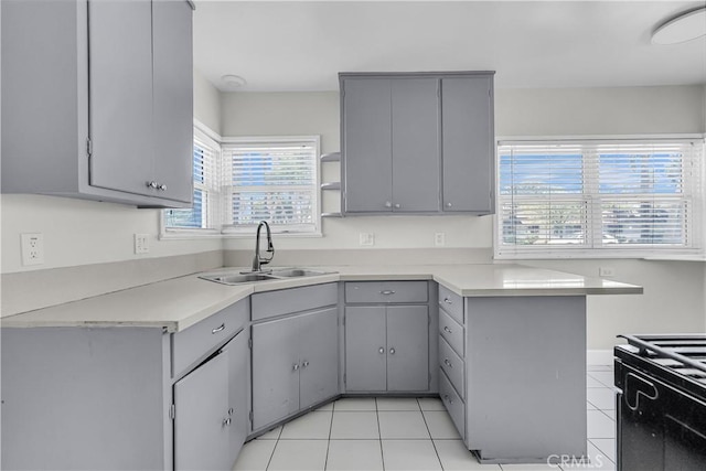 6017 Brockton Ave, Riverside, CA 92506 - kitchen with gray cabinets, stove, light countertops, and light tile patterned floors
