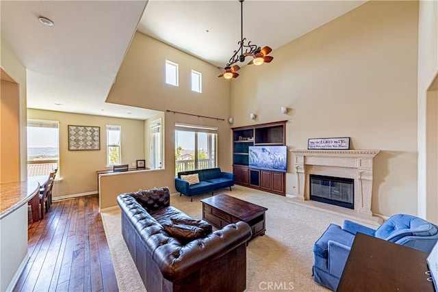 18956 Northern Dancer Ln, Yorba Linda, CA 92886 - living room with a chandelier, plenty of natural light, hardwood / wood-style floors, a high ceiling, and a high end fireplace