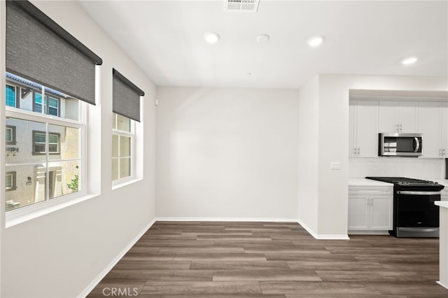 40497 Melrose Dr, Temecula, CA 92591 - kitchen with appliances with stainless steel finishes, white cabinets, wood finished floors, light countertops, and tasteful backsplash