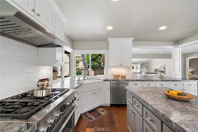 7543 E Twinleaf Trl, Orange, CA 92869 - kitchen with range hood, stainless steel appliances, tasteful backsplash, dark wood-style flooring, and light stone counters