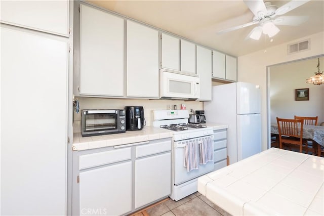 12356 Thistle Dr, Rancho Cucamonga, CA 91739 - kitchen with white appliances, tile counters, light tile patterned floors, white cabinetry, and a ceiling fan