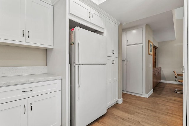 8815 Yuba Cir Unit 1102B, Huntington Beach, CA 92646 - kitchen with freestanding refrigerator, white cabinets, light wood-style flooring, and light countertops