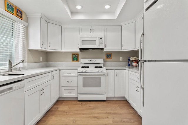 8815 Yuba Cir Unit 1102B, Huntington Beach, CA 92646 - kitchen with white appliances, a raised ceiling, white cabinets, recessed lighting, and light countertops